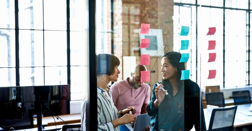 Business owner mapping options on a whiteboard to turn obstacles into opportunities