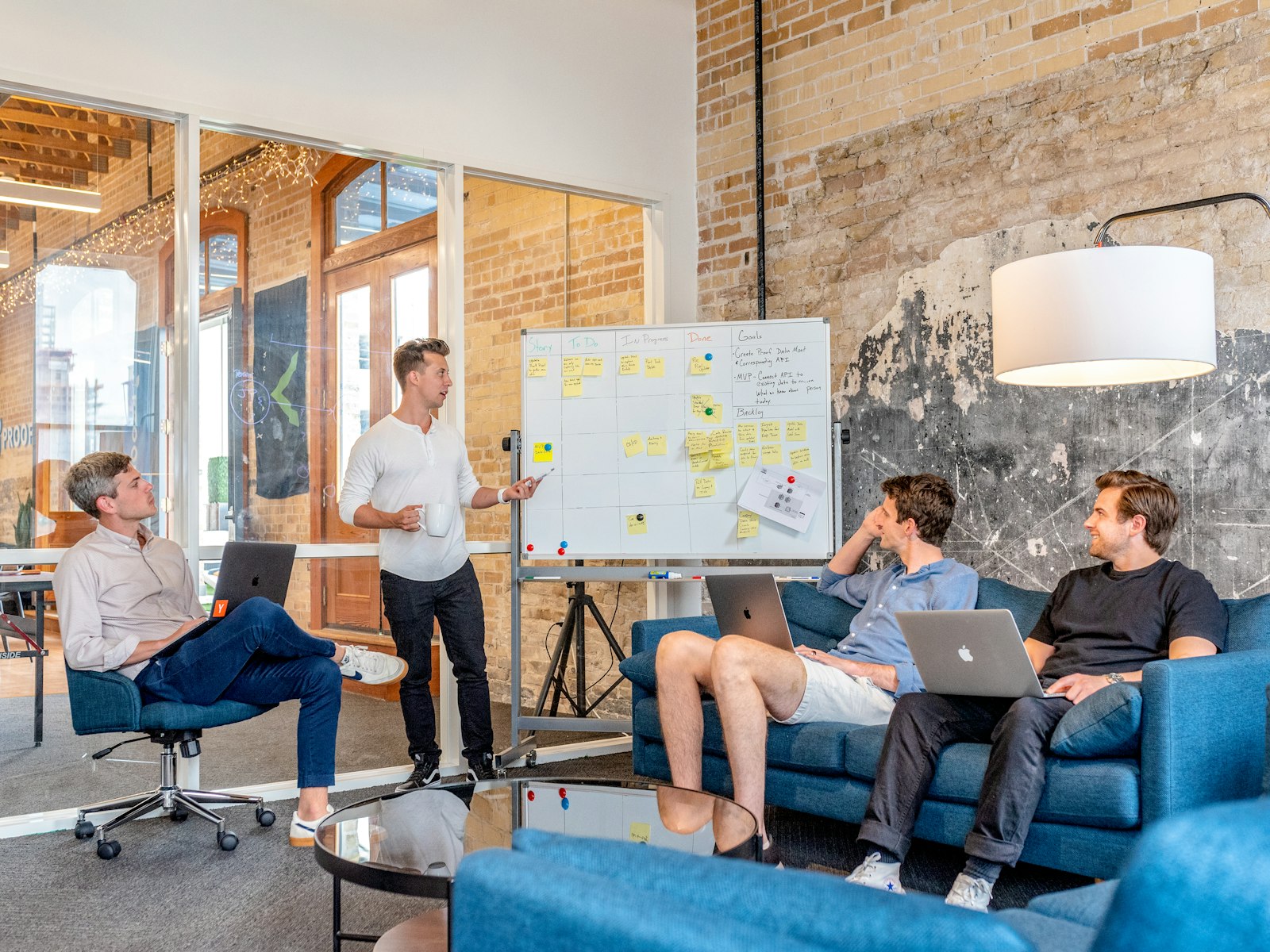 Small business team meeting around a sticky-note scoreboard