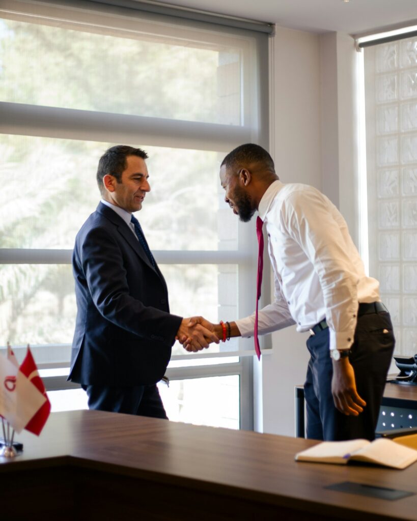Business owner and buyer shaking hands after agreeing how to sell a small business