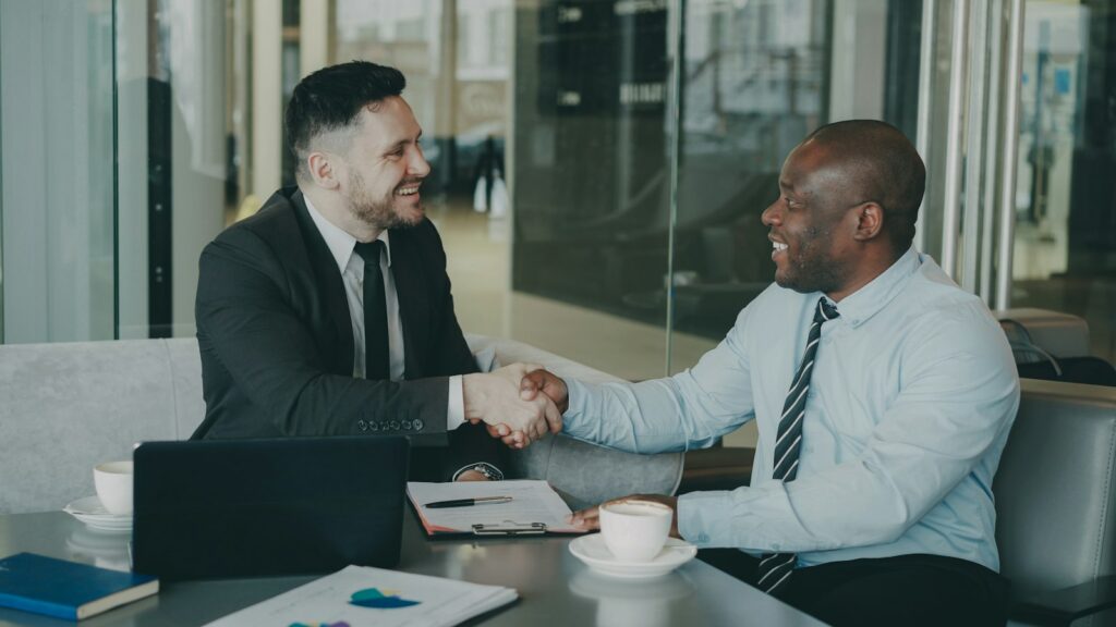 Account manager agreeing upselling and cross-selling options with a B2B client over coffee