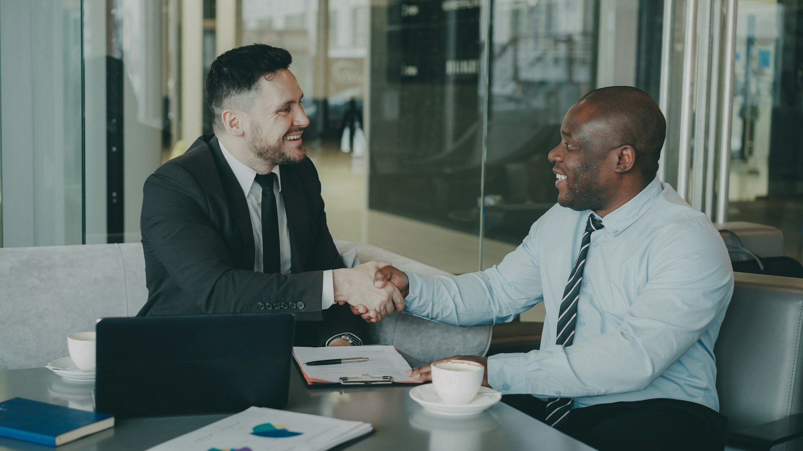 Account manager agreeing upselling and cross-selling options with a B2B client over coffee