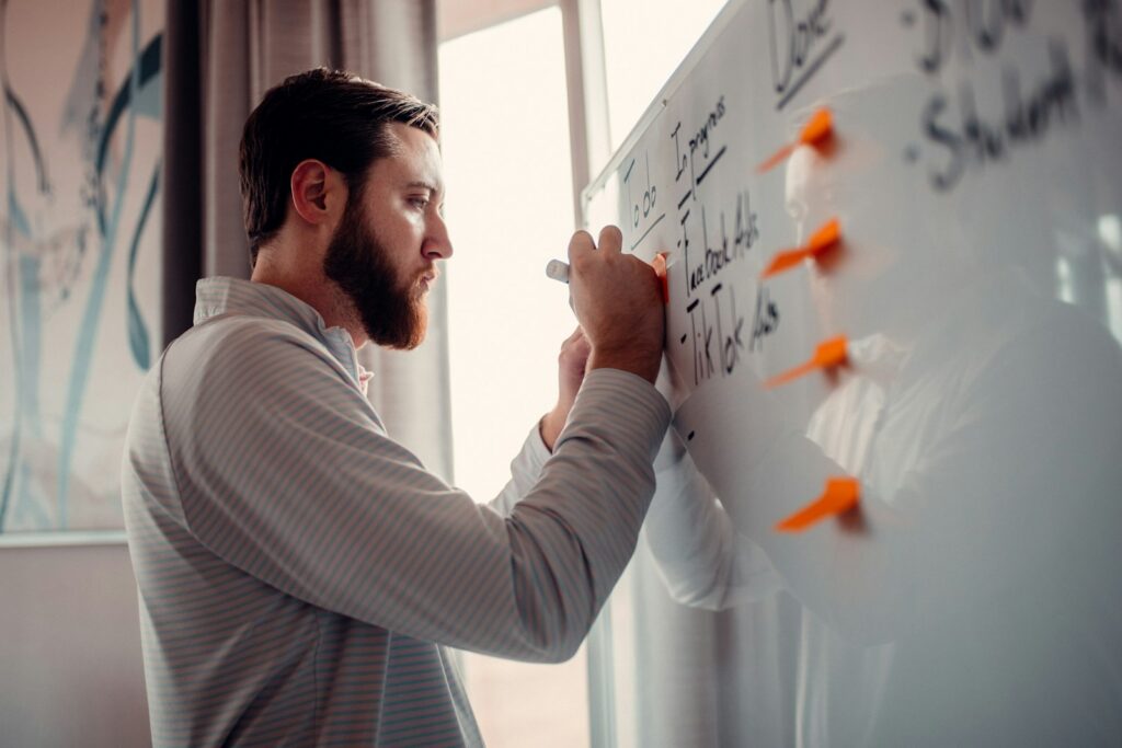 Small business team writing vision and mission statement examples on a whiteboard