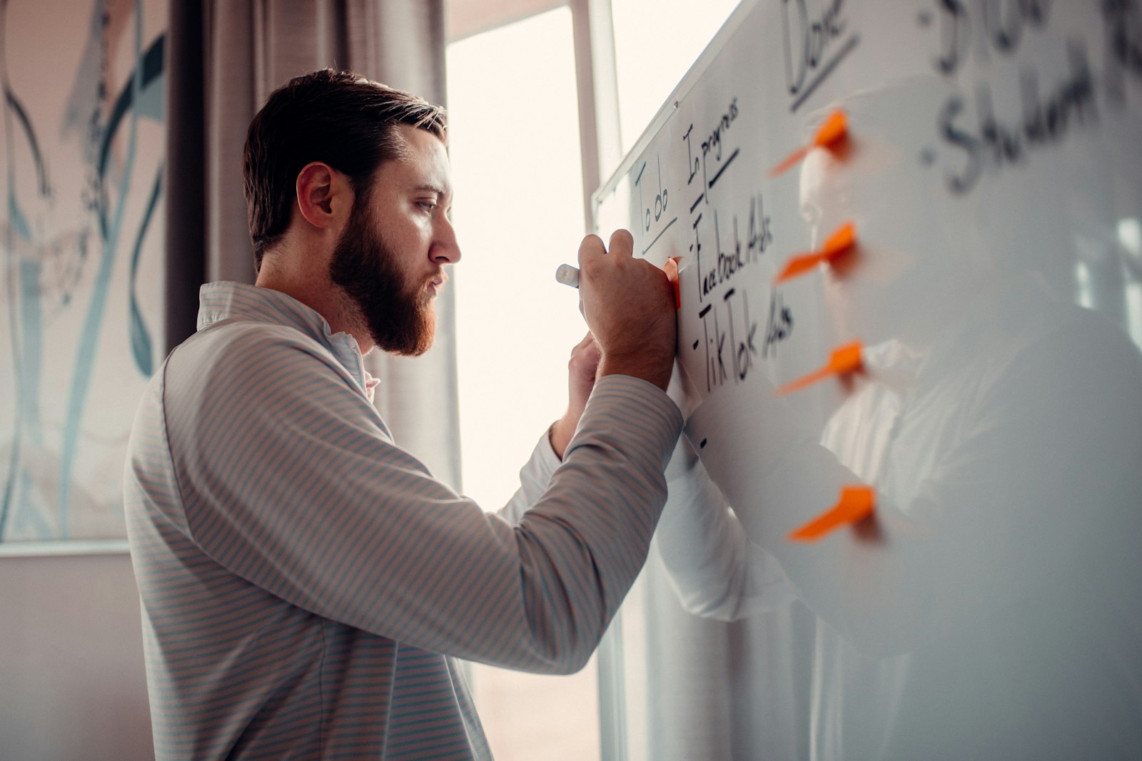 Small business team writing vision and mission statement examples on a whiteboard